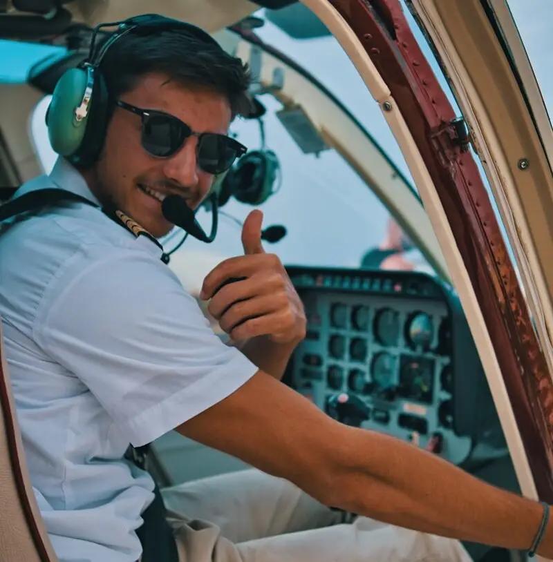 a man sitting in the cockpit of a plane giving a thumbs up